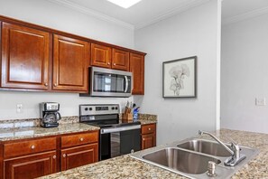 Enjoy cooking in this well-equipped kitchen with a microwave, stove, and sink.