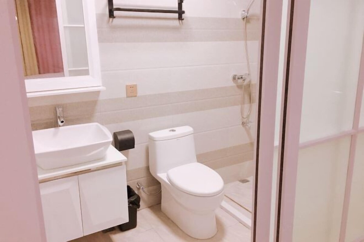 A bathroom with a white sink, toilet, and shower.