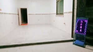 Ein Zimmer mit Fliesenboden, einer Tür zu einem anderen Raum und einem Neon-Schild mit chinesischen Schriftzeichen.