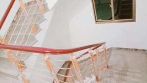 Eine Wendeltreppe mit roter Handläufe und einem Fenster auf der Zwischenebene.
