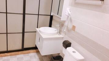 A small bathroom with a toilet, sink, and a trash bin.