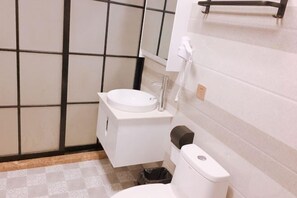 A small bathroom with a toilet, sink, and a trash bin.
