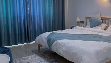 A bedroom with a bed, a nightstand, a lamp, and a ring light on the wall.