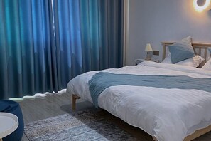 A bedroom with a bed, a nightstand, a lamp, and a ring light on the wall.