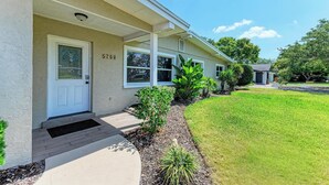 A building with a white door, number 51708, and a small porch with a bench. - PARADISE RETREAT A 3/2 PET FRIENDLY POOL HOUSE (Bradenton)