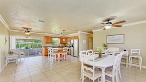A spacious kitchen with a dining area, white cabinetry, and a ceiling fan. - PARADISE RETREAT A 3/2 PET FRIENDLY POOL HOUSE (Bradenton)