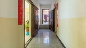 Un pasillo con puertas a ambos lados, que conduce a un espacio abierto con una mesa y sillas.