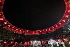 A circular structure with a central open area, possibly a courtyard or plaza, surrounded by walls with evenly spaced openings. - Yongding Qiaofu Building Doctor Home Inn (Longyan)