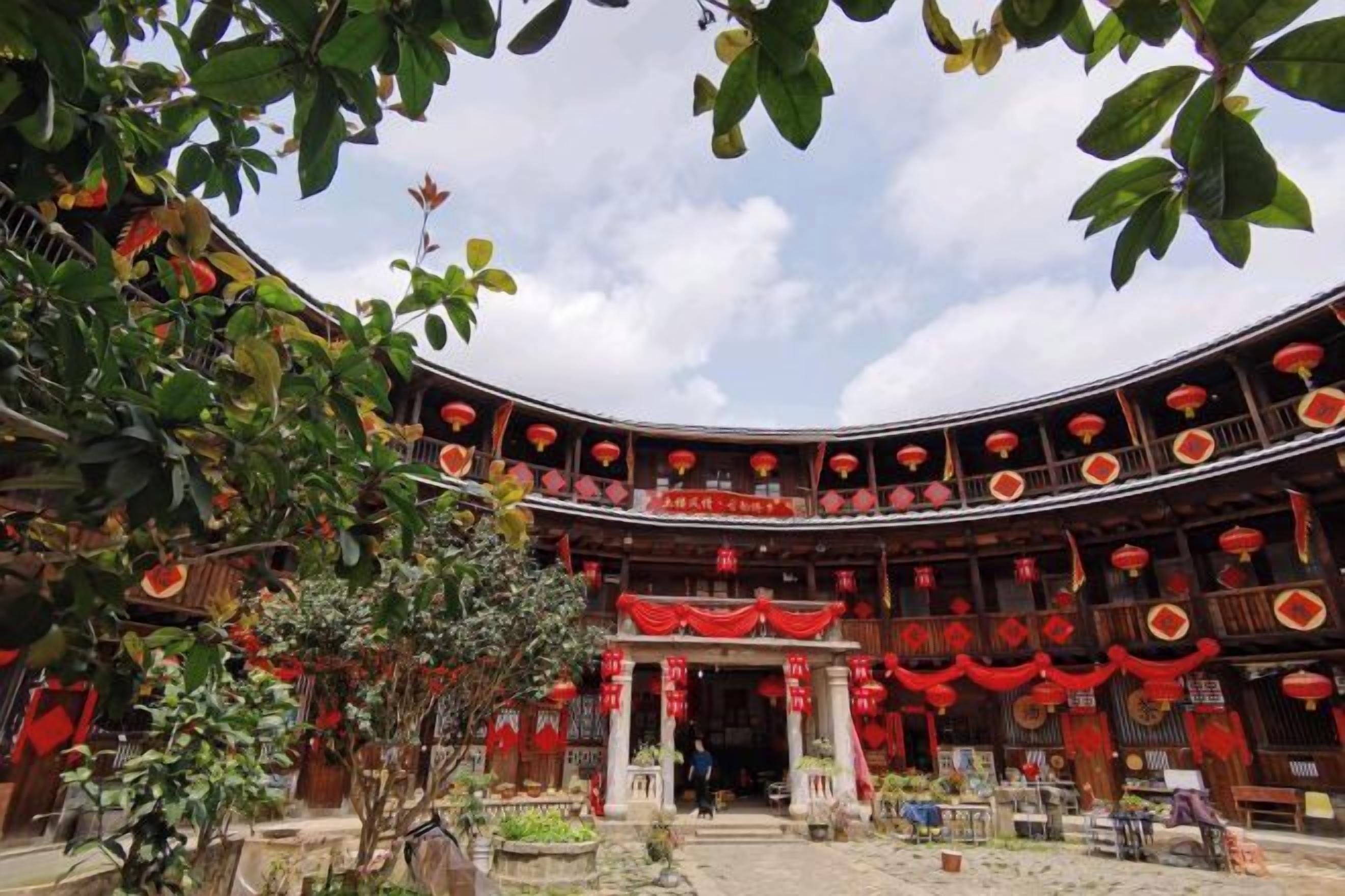 Un edificio tradicional con fachada curva, varios niveles y detalles en rojo.