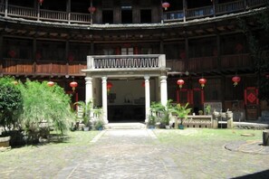 A courtyard with a central open space, surrounded by buildings with balconies and red lanterns. - Yongding Qiaofu Building Doctor Home Inn (Longyan)