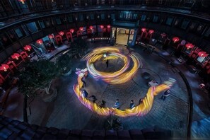 A circular seating area with a central light installation, surrounded by red lanterns and outdoor seating. - Yongding Qiaofu Building Doctor Home Inn (Longyan)