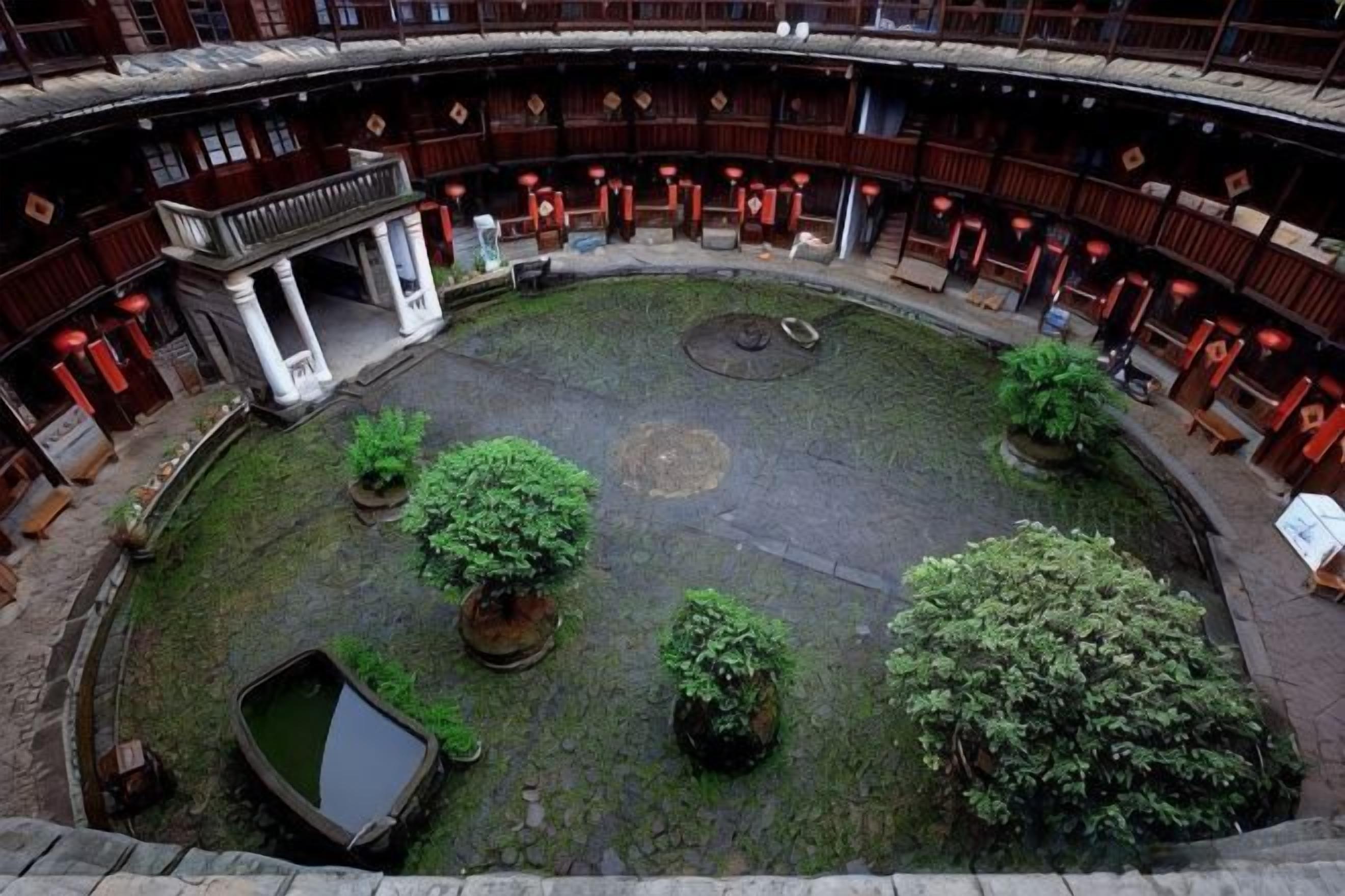 Un patio interior con una fuente central, rodeado de zonas de estar y un edificio de arquitectura tradicional.