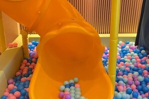 A children's play area with a slide and a ball pit filled with multicolored balls. - Freely Hover Golden Shuitai Hot Spring Town (Xinxing)
