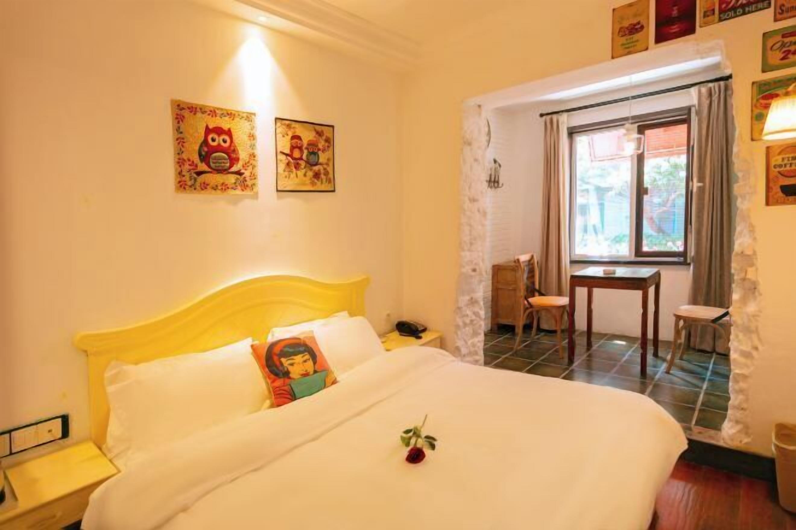 A hotel room with a bed, a desk, and a window.