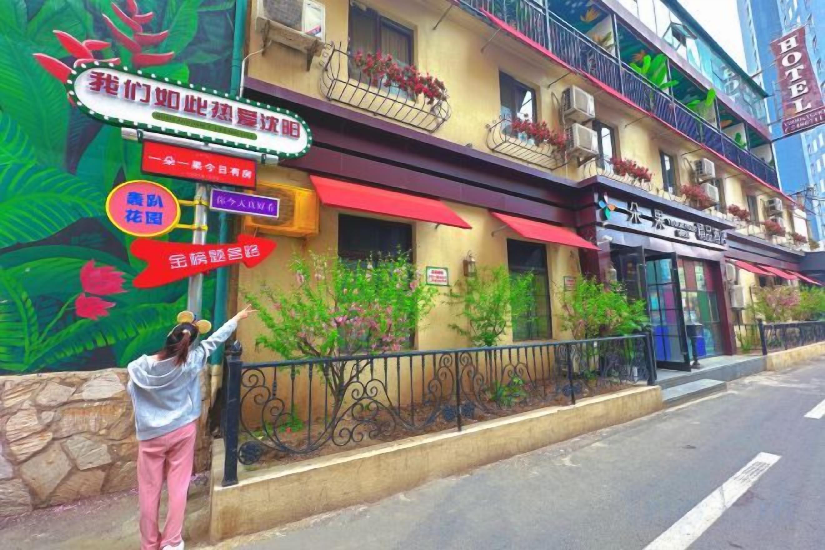 A hotel with a colorful mural, a red awning, and a sign indicating a restaurant.