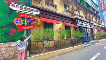 A hotel with a colorful mural, a red awning, and a sign indicating a restaurant.