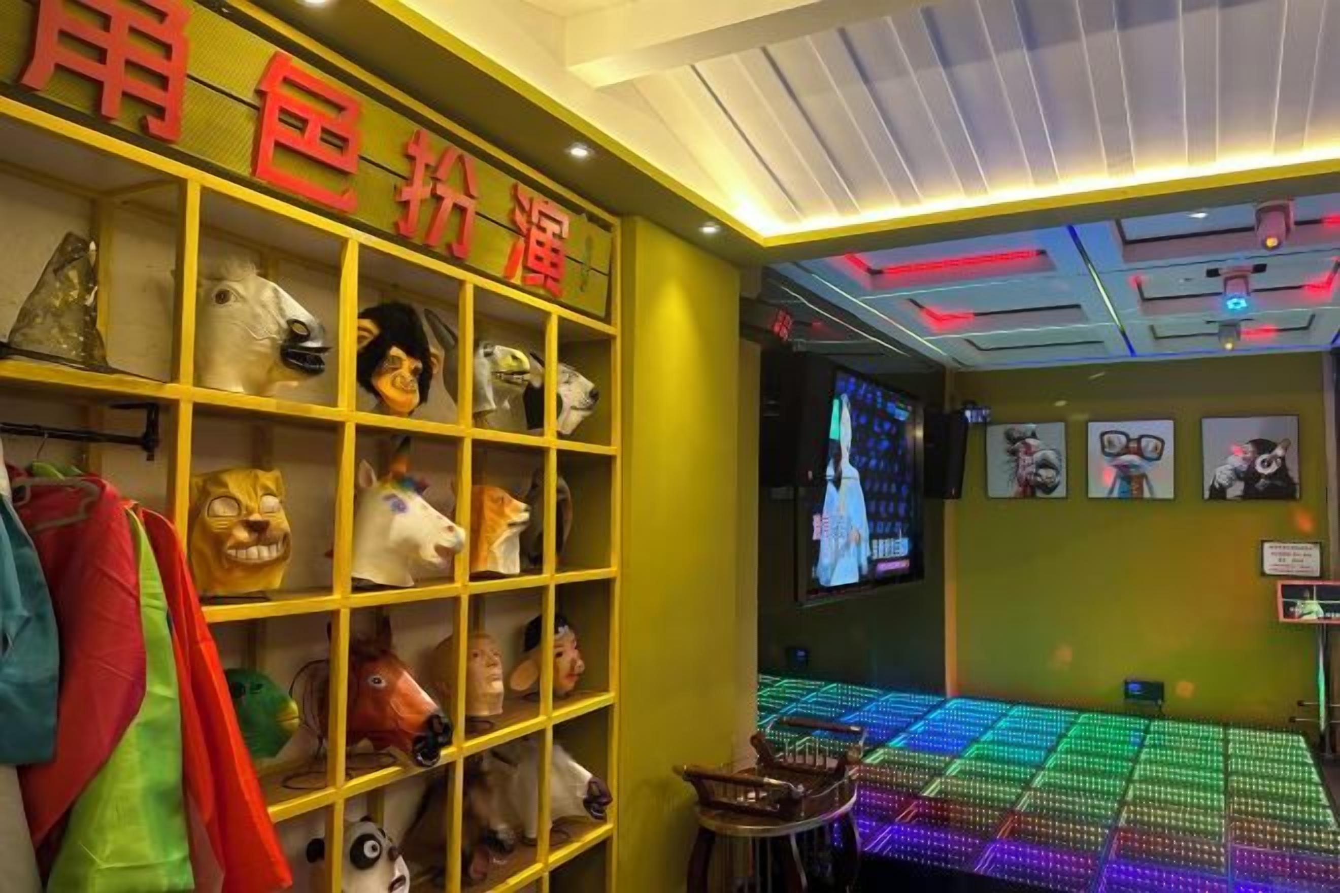 A room with a shelf of animal head masks, a television screen, and a neon light display.