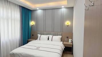 Una habitación de hotel con cama, mesita de noche y luces en la pared.