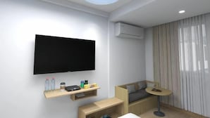 A modern living room with a flat-screen TV, wooden shelves, a sofa, a small round table, and a ceiling with a circular skylight. - Xiaocheng Zhilv Hotel (Cenxi)
