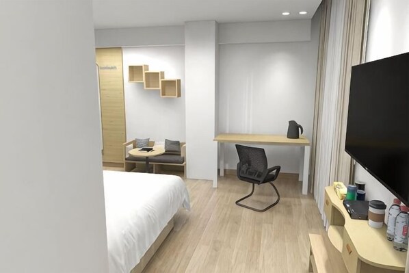 Habitación de hotel con cama, escritorio, silla, televisor y un pequeño rincón de descanso con mesa y sillas.