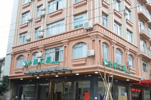 Un hotel de varios pisos con un estilo arquitectónico clásico, con ventanas en arco y una entrada central.