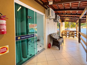 A guest house with a glass door, a fire extinguisher, and a sign indicating the room number 305. - Pousada Mel e Mar (Penha)
