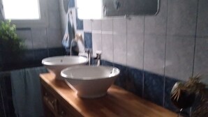 A bathroom with two sinks, a mirror, and a wooden vanity. - La Chapelle (Teloché)