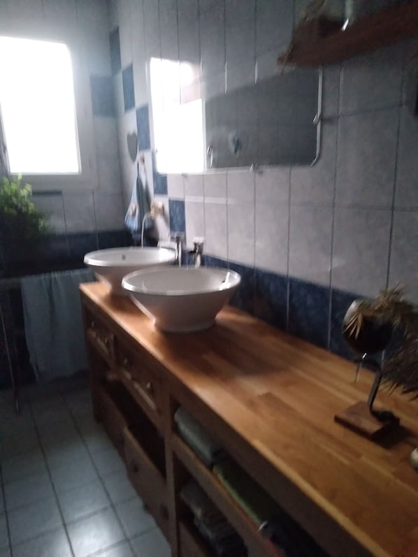 Un baño con dos lavamanos, un espejo y un mueble de tocador de madera.