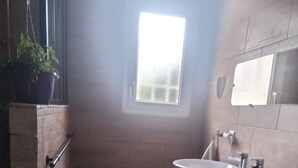 A bathroom with two sinks, a window, a potted plant, and a wooden vanity. - La Chapelle (Teloché)