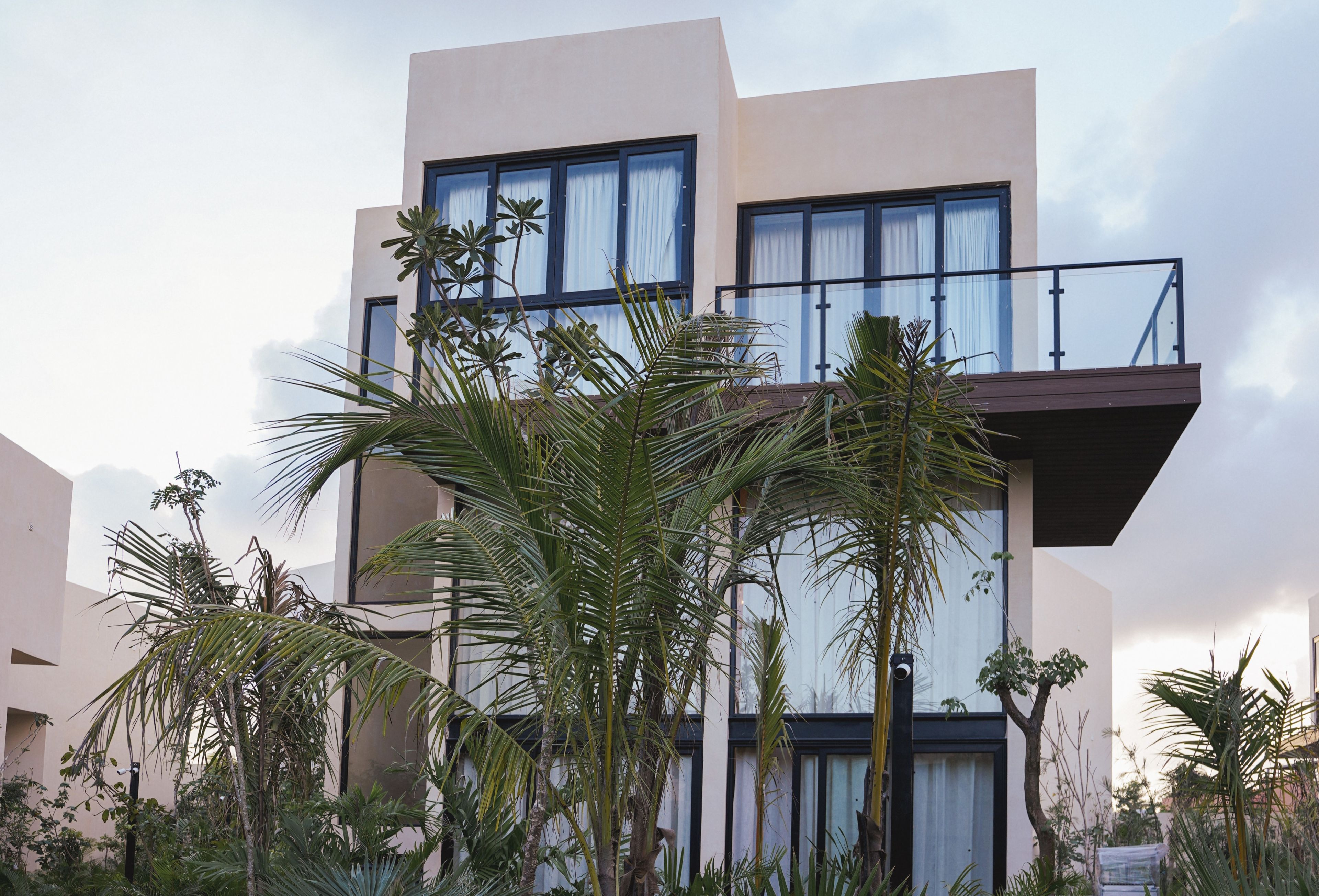 Un bâtiment moderne à deux étages, doté de grandes fenêtres et d’un balcon.