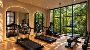 A gym with treadmills, stationary bikes, and benches, large windows with a view of greenery. - Trobbu Boutique Collection Riviera Maya - All Inclusive (Tulum)