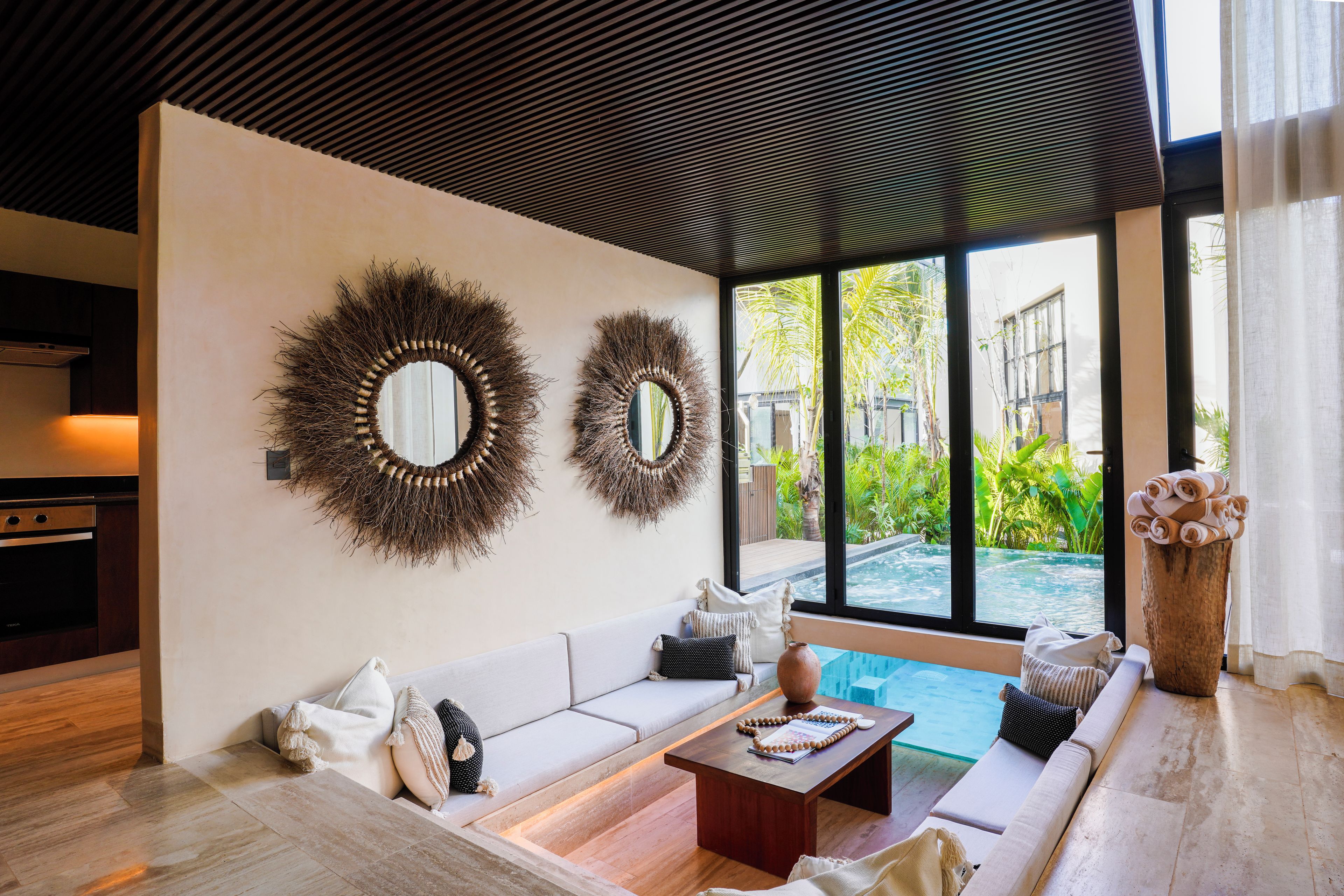 Una sala de estar moderna con sofá, mesa de centro y espejos decorativos.
