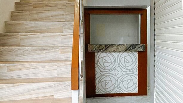 A staircase with a patterned wall and a door with a circular design. - Leonila S Travellers Inn (Iloilo)