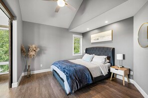 Un dormitorio con cama, mesita de noche, lámpara y ventilador de techo.