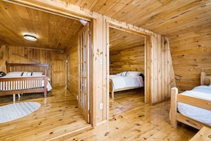 A wooden cabin with two single beds, a wooden ceiling, and a small window. - Knotty Pines 4 Bedroom with Waterfront Views (McKinleyville)