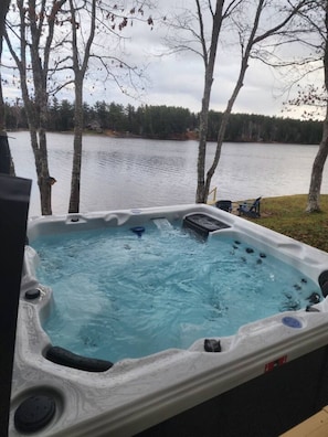 Un bain à remous avec vue sur un lac et des arbres.