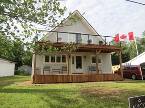 A single-story house with a porch, a Canadian flag, and a number 19 on the door.