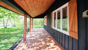 Una terraza cubierta de madera con vista a un paisaje verde.