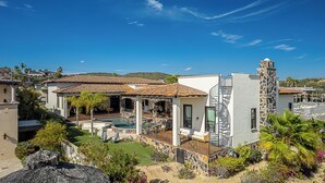 A residential property with a swimming pool, outdoor seating, and a stone staircase.