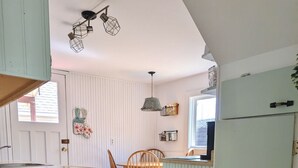 Una cocina con armarios de madera, una mesa de comedor con sillas y una ventana.