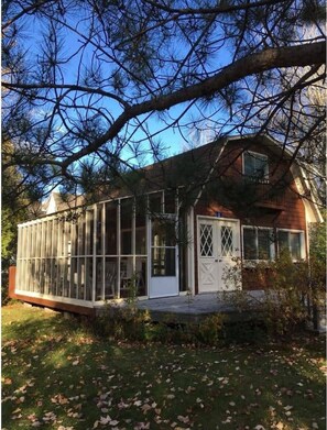 Une maison dotée d’une grande véranda en verre attenante au bâtiment principal.
