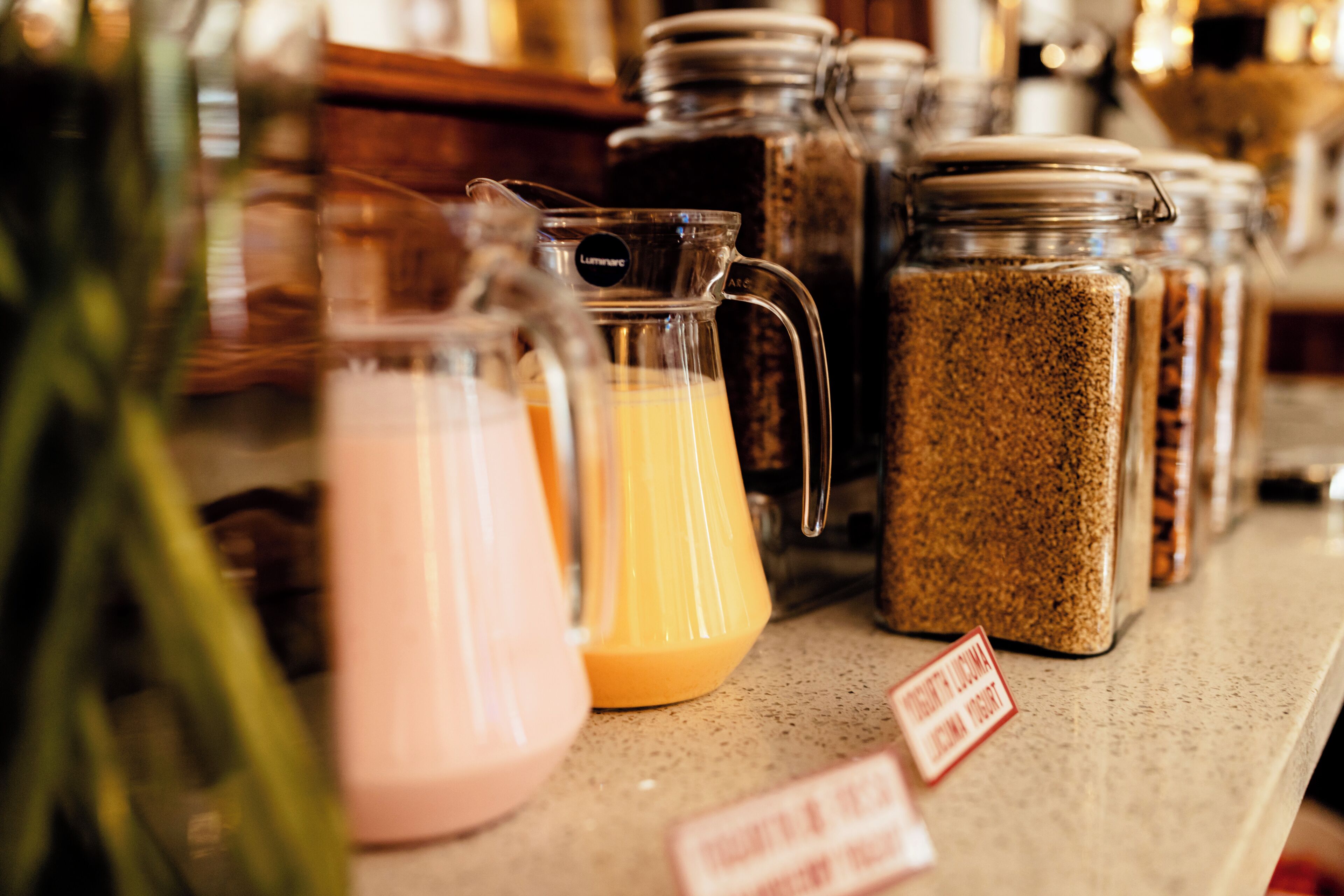A kitchen counter with various containers and a pitcher.