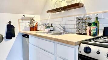 Cafetera o tetera, frigorífico, horno y placa de cocina