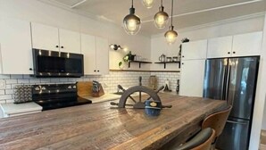 A modern kitchen with a wooden island, stainless steel appliances, and pendant lighting. - 2 bedroom home, Sleeps 6 (Alma)