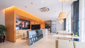 A modern hotel lobby with a reception desk, seating area, and a large window. - Jinjiang Inn (Wuxi Anzhen) (Wuxi)