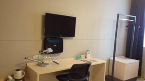 A hotel room with a desk, chair, television, and a shower area. - Jinjiang Inn (Wuxi Anzhen) (Wuxi)