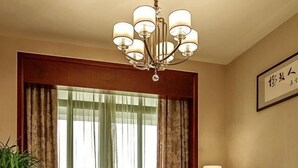 A living room with a sofa, a coffee table, a lamp, a potted plant, and a chandelier. - Jinjiang Inn (Wuxi Anzhen) (Wuxi)