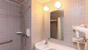 A bathroom with a shower, a sink, a mirror, and a hairdryer. - Jinjiang Inn (Wuxi Anzhen) (Wuxi)