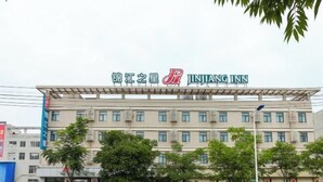 A multi-story building with a sign for 'JINJANG INN' at the top. - Jinjiang Inn (Wuxi Anzhen) (Wuxi)