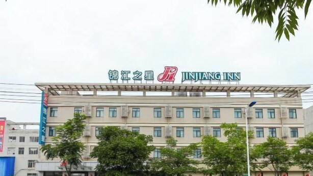 A multi-story building with a sign for 'JINJANG INN' at the top. - Jinjiang Inn (Wuxi Anzhen) (Wuxi)